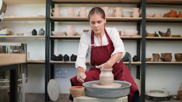 Keramikverkstad, kvinnlig krukmakare gör en kanna av lera, hantverk, produktion av handgjorda bordsartiklar, hantverk. — Stockvideo