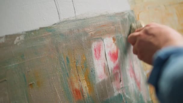 Zpomalený, kreativní člověk v práci, talentovaný muž umělec zakrývá plátno olejomalbou, základní a kreslí pozadí, vytváří abstraktní obraz. — Stock video