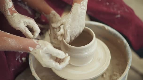 Bovenaanzicht, productie van handgemaakt servies, het jonge koppel pottenbakker maakt een kruik van klei, close-up zicht op de handen, handwerk, aardewerk workshop. — Stockvideo
