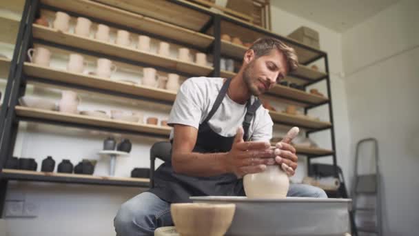 Ambachten, de man pottenbakker maakt een kruik van klei, handwerk, productie van handgemaakt servies, aardewerk workshop. — Stockvideo