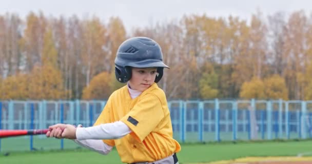 Bulanık arka planda bir erkek beyzbol oyuncusunun portresi, koruyucu giysili vurucu, uçan bir topu bekliyor, topa vurmaya hazırlanıyor, 450 fps. — Stok video