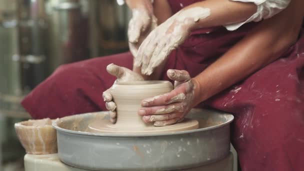 Joint work, production of handmade tableware, the young couple potter makes a pitcher out of clay, top view of the hands. — Stock Video