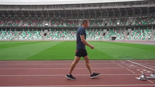 Estádio, homem sprinter está se preparando para o início de uma corrida de treinamento em curta distância, 4k câmera lenta. — Vídeo de Stock