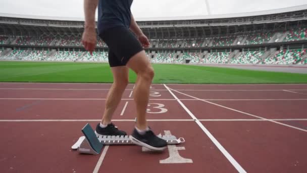 Estádio, homem sprinter está se preparando para o início de uma corrida de treinamento em curta distância, corredor de pista profissional, 4k câmera lenta. — Vídeo de Stock