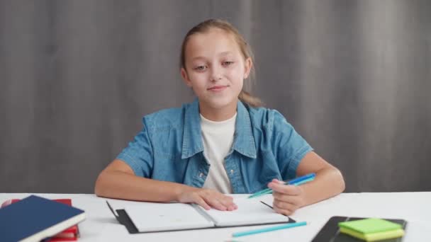 遠隔学習オンラインビデオコールで、 10代の女の子はリビングルームで職場に座って、自宅で自己分離で勉強するためにウェブカメラを使用しています. — ストック動画