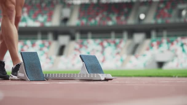 Man sprinter is preparing for the start of a training run in short-distance, professional track runner at a stadium, a tense moment, handheld. — Stock Video