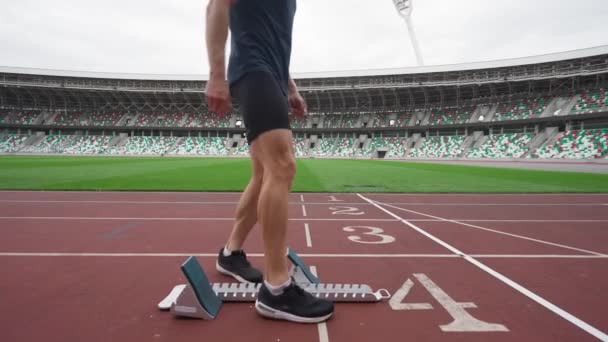 Stadion, professionell man sprinter förbereder sig för starten av en träning i kortdistans, löparbana, 4k slow motion. — Stockvideo
