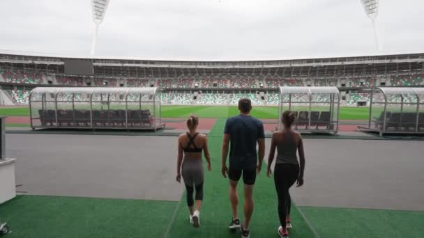 Os velocistas profissionais vão para o estádio olímpico, visão traseira, competições de corrida, atletas olímpicos masculinos e femininos caminham pelo estádio, 4k Slow Motion. — Vídeo de Stock
