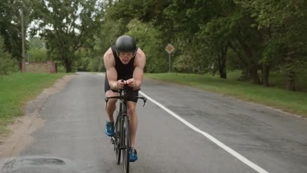 Homem triatleta monta uma bicicleta, passeios de ciclista pro em uma estrada, treinamento de atleta para triatlo, 4k super câmera lenta. — Vídeo de Stock