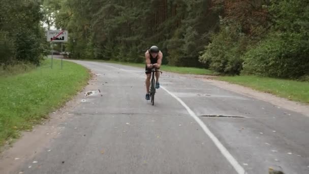 Widok z przodu, człowiek triathlete jeździ na rowerze, pro rowerzysta jeździ po drodze, sportowiec trening na rowerze tnącym, 4k super slow motion. — Wideo stockowe