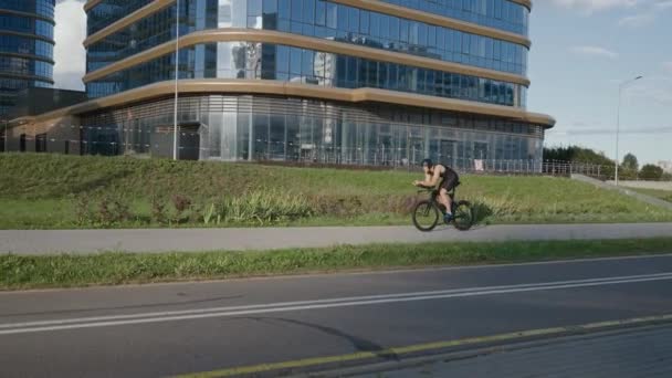 Un robusto triatleta va in bicicletta, un ciclista professionista guida su una strada urbana, un atleta si allena in un ambiente urbano su una bicicletta da taglio. — Video Stock