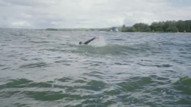 Dalgıç kıyafetli sıkı bir triatloncu açık denizde yüzer, bir atlet triatlon yarışmasından önce antrenman yapar, 4k süper yavaş çekim.