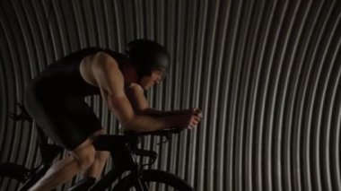 Profesyonel triatlet bisiklet sürüyor, tünelde profesyonel bisikletçi, yarış için atlet eğitimi, 4k yavaş çekim.