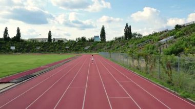 Varşova, Polonya - 18 Temmuz 2025: Sabah koşusu, güneşli bir günde bir stadyumda koşan sporcu kadın, günlük antrenman yarı maratonu, başarılar.