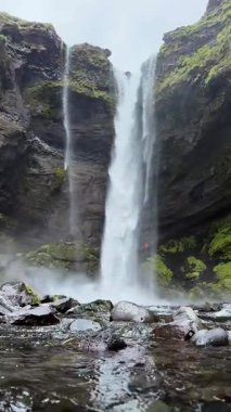 Vertical video, Iceland landscape, first person view of the huge waterfall, slow motion mountain Iceland nature, serenity waterfall view, melting glacier flow of water, UGC.