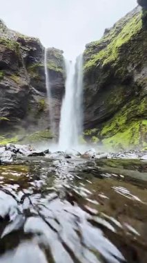 Vertical video, Iceland landscape, first person view of the huge waterfall, slow motion mountain Iceland nature, serenity waterfall view, melting glacier flow of water, UGC.