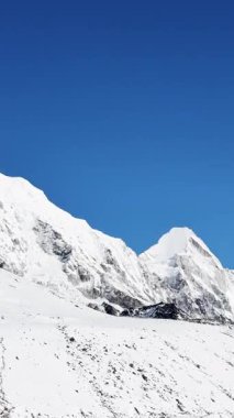 Himalayalar bulutların altında, UGC, karlı dağların görkemli manzarası, Himalayalar 'ın beyaz karla kaplı bir dağ sırasının doğa arka planı, kayalık arazi vadisi, taş dağlar.