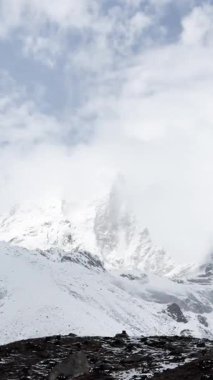 Himalayalar bulutların altında, UGC, karlı dağların görkemli manzarası, Himalayalar 'ın karla kaplı bir dağ sırasının doğa arka planı, kayalık arazi vadisi.