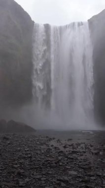 İzlanda manzarası, pov, büyük şelalenin görkemli manzarası, İzlanda doğası, dinginlik su akışı, kayalık arazi arka planı, eriyen buzullar, kamera sallaması.