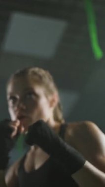 Profesyonel kadın boksör yumruklarını yener ve eğitir, boks salonunda sıkı antrenman yapar, kadın hızlı ve dikey video çeker..