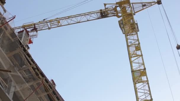 A construção de edifícios de concreto, um guindaste de torre — Vídeo de Stock