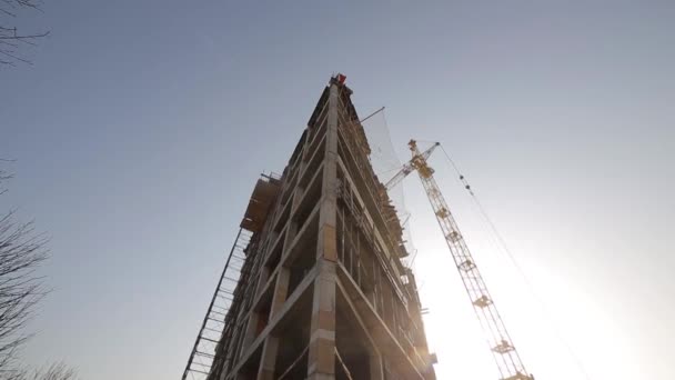 A construção de edifícios de concreto, um guindaste de torre — Vídeo de Stock