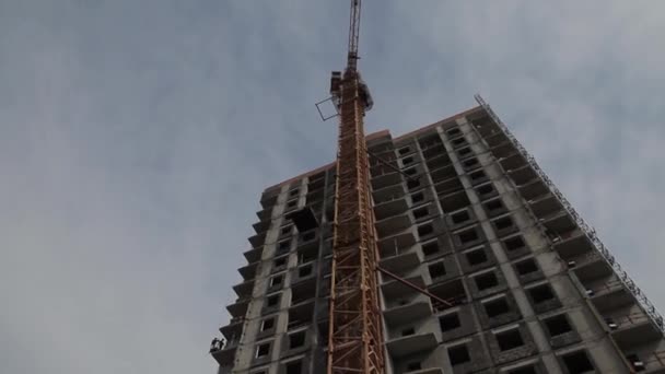 The construction of concrete buildings, a tower crane — Stock Video