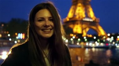 Mutlu kız akşam Paris'te Eyfel Kulesi gülümseyen