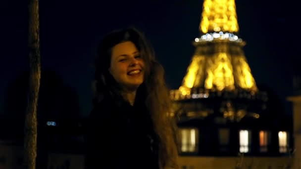 Ευτυχισμένος κορίτσι χαμογελά τη νύχτα του χρόνου σε τον πύργο του Άιφελ στο Παρίσι — Αρχείο Βίντεο