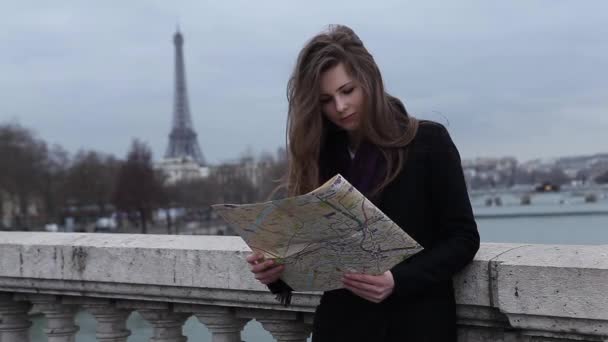 Menina procurando mapa em Paris na Torre Eiffel — Vídeo de Stock