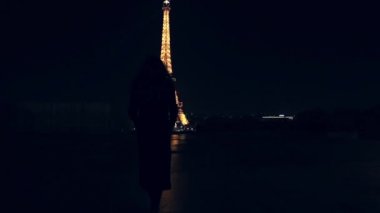 Geliyor ve Eyfel Kulesi üzerinde derin gece izlerken kız