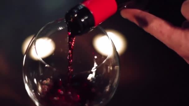 Wijn stroomt in een glas op een avond-datum in slow motion — Stockvideo
