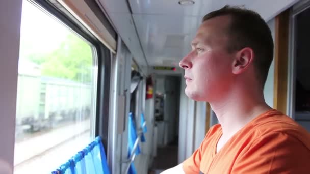 ウィンドウを探している列車で旅の男 — ストック動画
