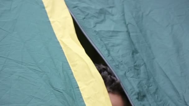 Männerkopf schaut aus dem Zelt — Stockvideo