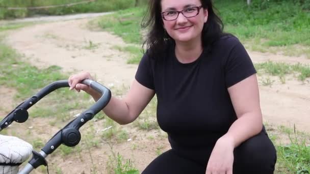 Joven madre feliz con el transporte del bebé — Vídeo de stock