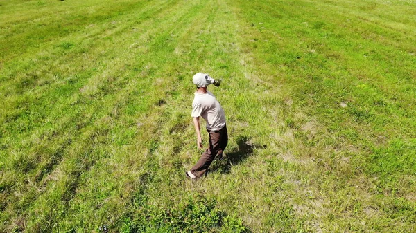 Hombre divertido en máscara de gas bailando al aire libre en un prado verde, vista superior drone, desde arriba, surrealista, alegría —  Fotos de Stock