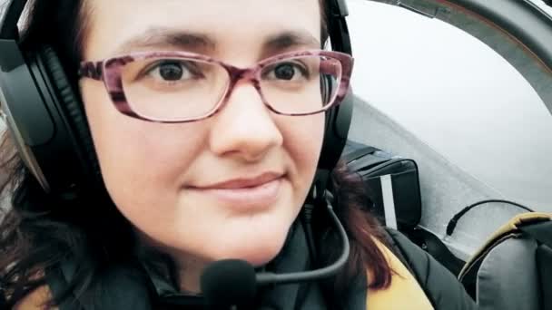Kadın pilot uçak uçuruyor, yakın plan portre, sevimli genç mutlu gülücük, hobi özgürlük kavramı gökyüzü — Stok video
