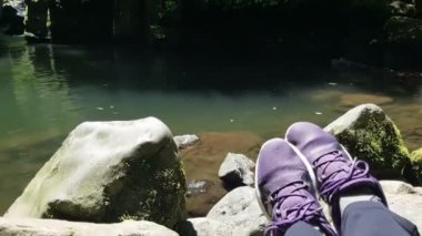 Gezgin botları Dağ Gölü yakınlarındaki taşların üzerinde, Pov turizm konsepti, cep telefonuyla çekilmiş.