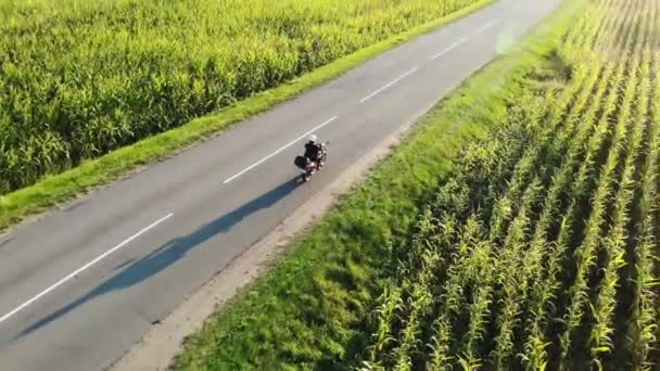 Motorradfahren auf der Landstraße bei Sonnenuntergang, schöne Abenteuerreiseaufnahmen von der Drohne, oben — Stockvideo