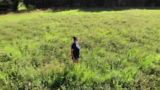 Mooie vrouw in masker staan alleen in een veld, geïsoleerde, antenne schot — Stockvideo