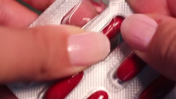 Hände nehmen rote Pille aus der Packung — Stockvideo