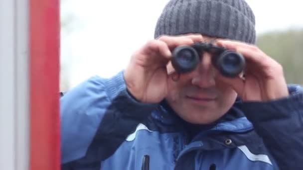 Man op straat met een verrekijker — Stockvideo