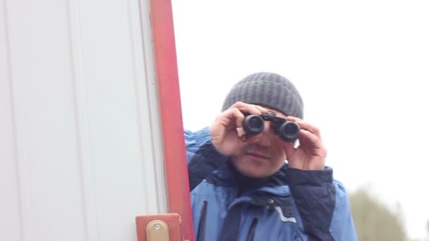 Uomo con binocolo dietro la recinzione — Video Stock