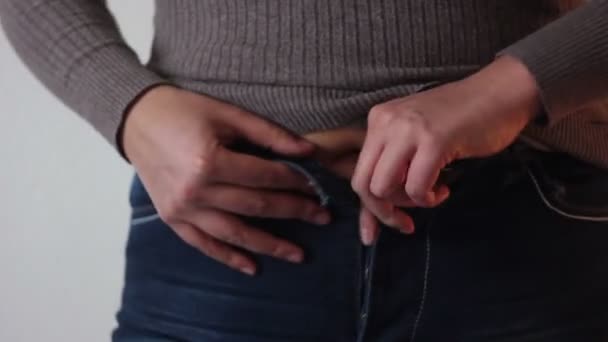 Das Ausziehen enger Jeans löst wachsenden Magen aus — Stockvideo