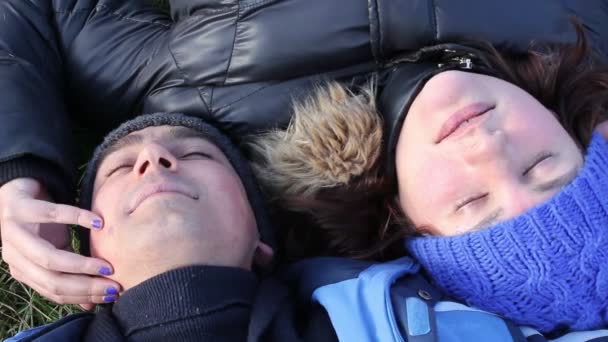 Мужчина и женщина, лежащие на траве — стоковое видео