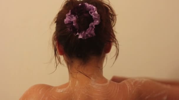 Женщина полирует шею в душе — стоковое видео