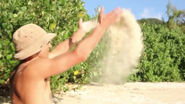 Man overgeven zand op het strand — Stockvideo