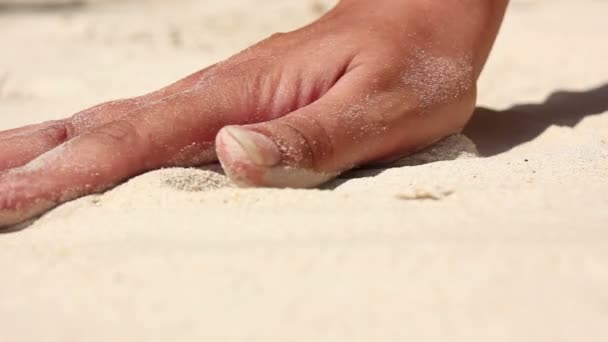 Main féminine touchant sable blanc — Video