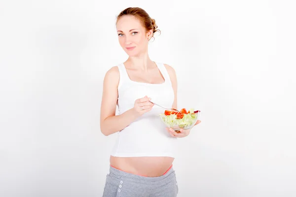 Giovane donna incinta mangiare insalata fresca — Foto Stock