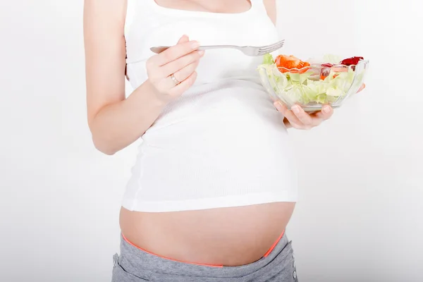 Giovane donna incinta mangiare insalata fresca — Foto Stock